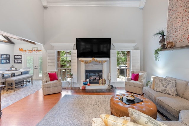 living room with hardwood / wood-style flooring, french doors, a premium fireplace, and a wealth of natural light