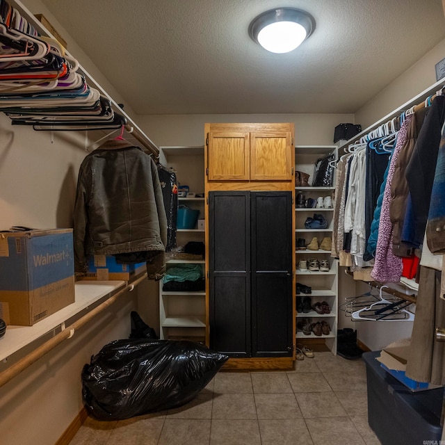 walk in closet with light tile patterned floors