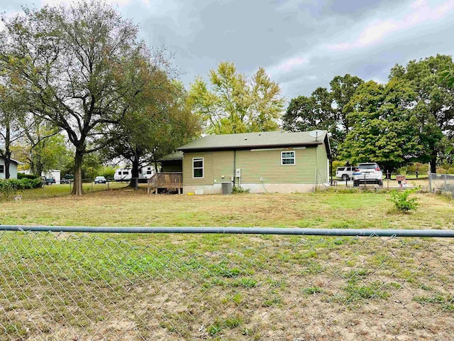 back of property with a lawn and a deck