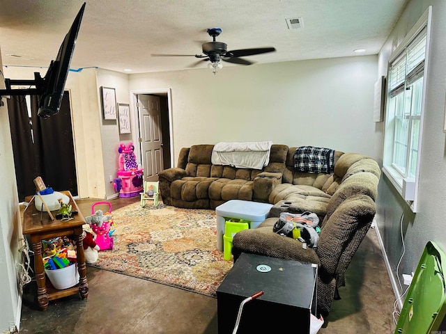 living room featuring ceiling fan and a textured ceiling