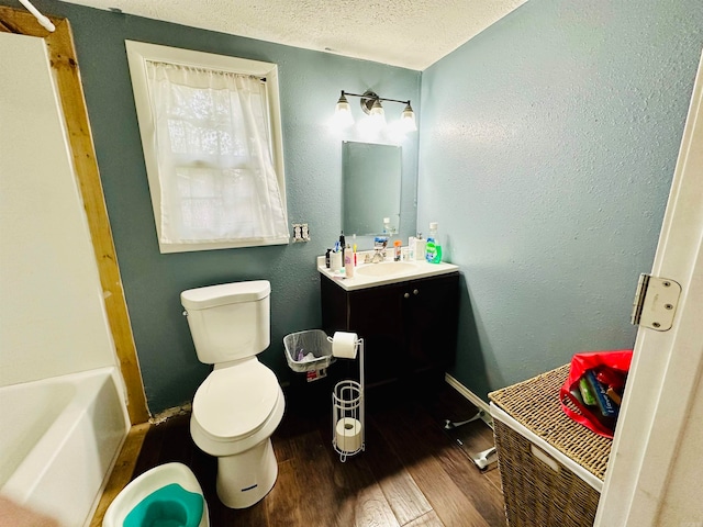 full bathroom featuring vanity, a textured ceiling, wood-type flooring, shower / tub combination, and toilet