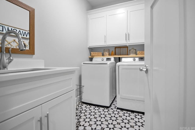 laundry room featuring washer and clothes dryer, sink, and cabinets