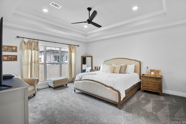 bedroom with ornamental molding, dark colored carpet, a tray ceiling, and ceiling fan