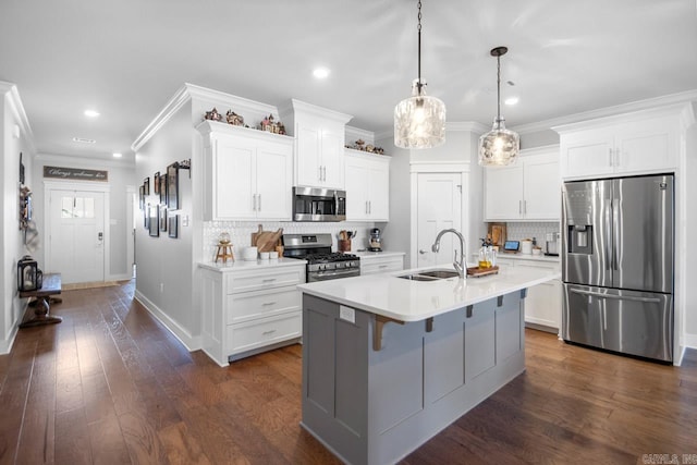 kitchen with pendant lighting, white cabinets, sink, dark wood-type flooring, and stainless steel appliances