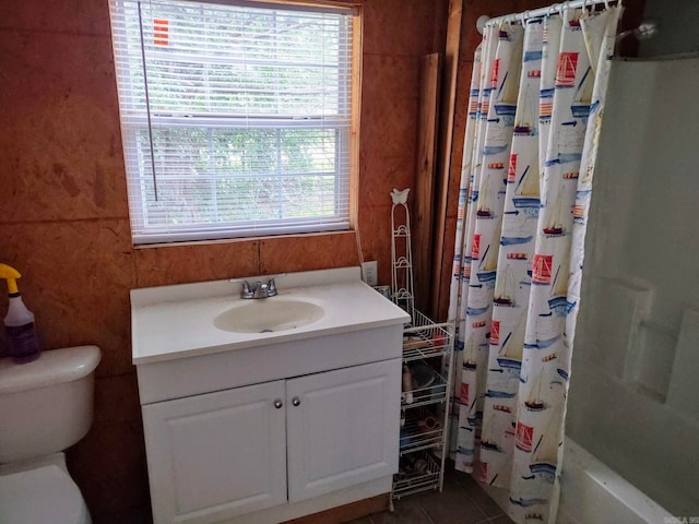 full bathroom with shower / bath combo, vanity, toilet, and a wealth of natural light