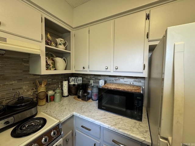 kitchen with white cabinets, light stone countertops, white appliances, and decorative backsplash