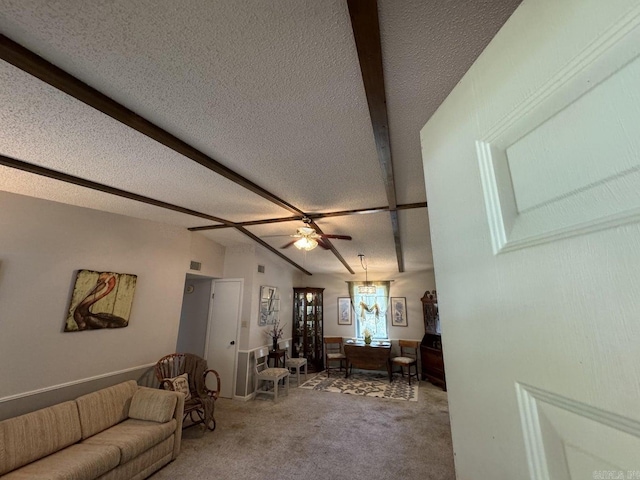 unfurnished living room with ceiling fan, carpet floors, lofted ceiling with beams, and a textured ceiling