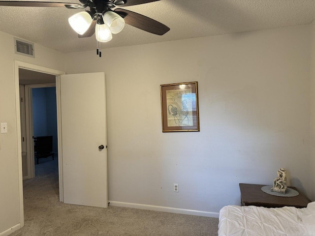 bedroom featuring a textured ceiling, ceiling fan, and light colored carpet