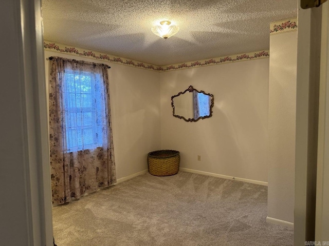 carpeted spare room with a textured ceiling