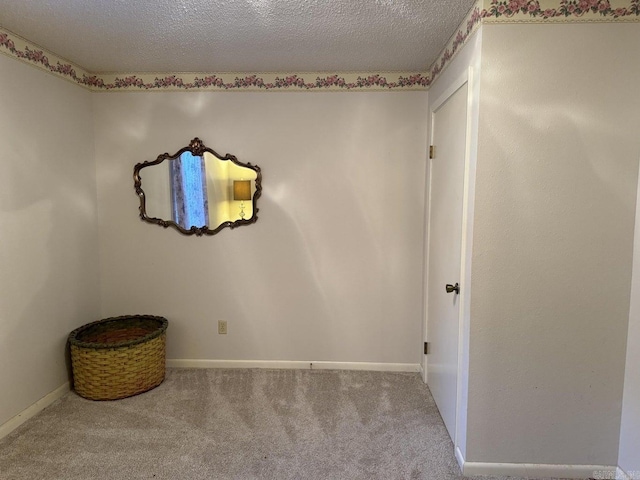 carpeted empty room with a textured ceiling