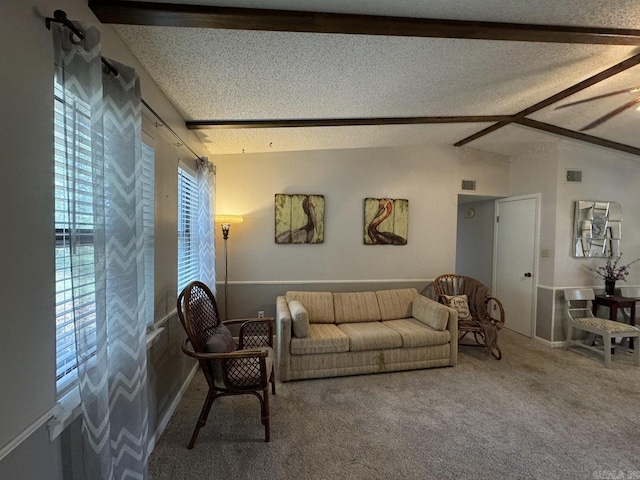 carpeted living room with a textured ceiling and vaulted ceiling with beams