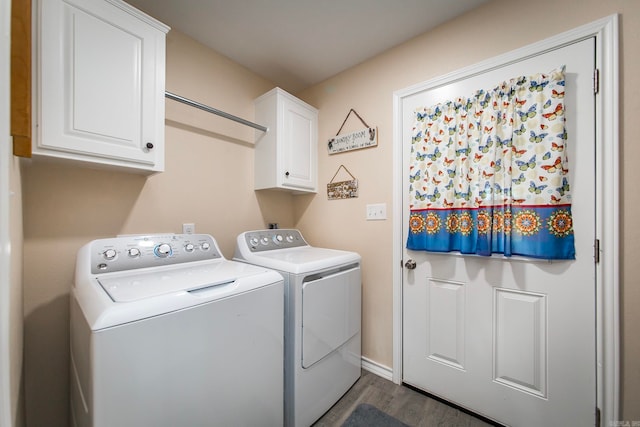 clothes washing area featuring washing machine and dryer, dark hardwood / wood-style flooring, and cabinets