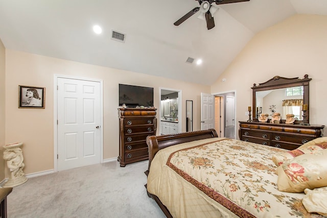 bedroom featuring light carpet, lofted ceiling, ensuite bath, and ceiling fan