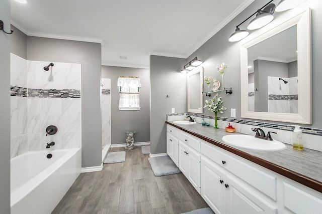 bathroom with wood-type flooring, tiled shower / bath, vanity, and crown molding