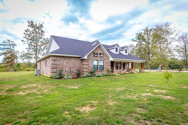 view of front of home with central AC and a front yard