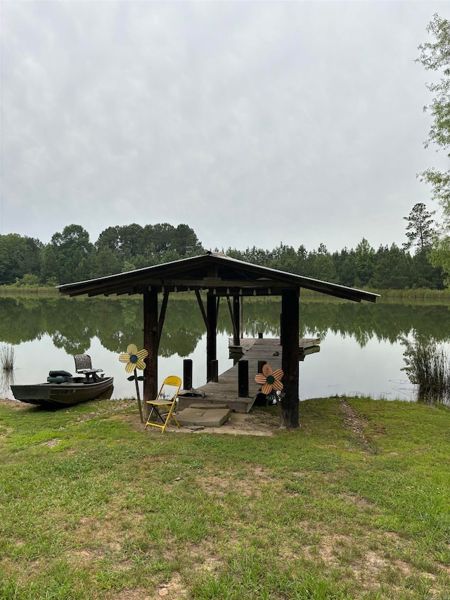 view of dock with a water view and a yard