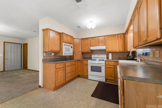 kitchen with a textured ceiling, sink, light colored carpet, decorative backsplash, and white appliances