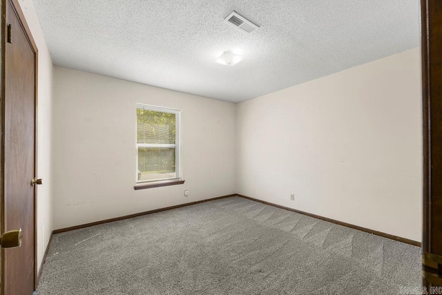 carpeted empty room featuring a textured ceiling