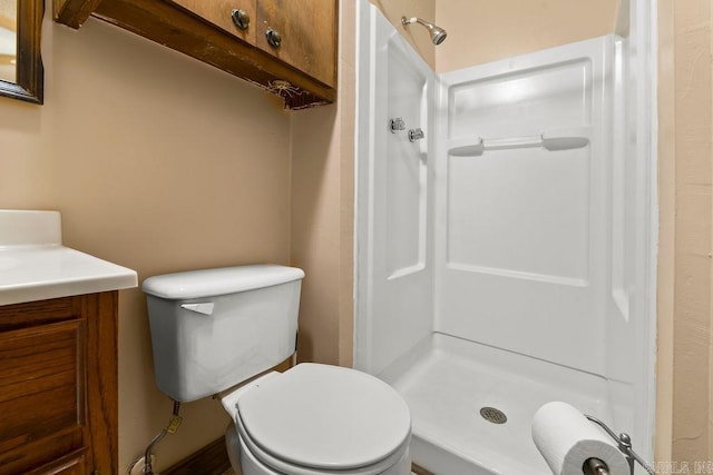 bathroom with walk in shower, vanity, and toilet