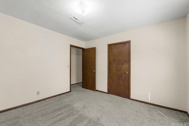 unfurnished bedroom with a textured ceiling, light colored carpet, and a closet