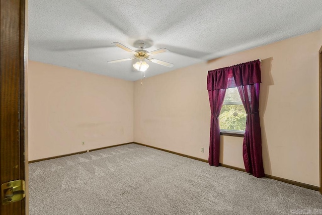 spare room featuring a textured ceiling, ceiling fan, and light colored carpet