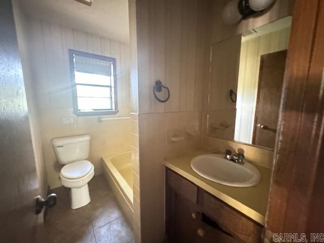 bathroom featuring vanity, tile walls, toilet, and tile patterned floors