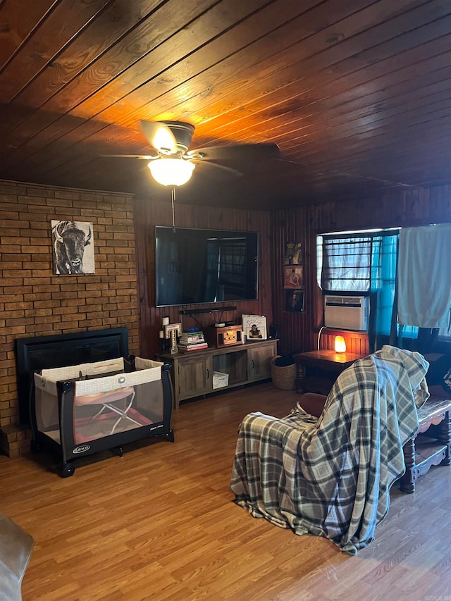 living room with wood-type flooring, wood ceiling, wooden walls, and ceiling fan