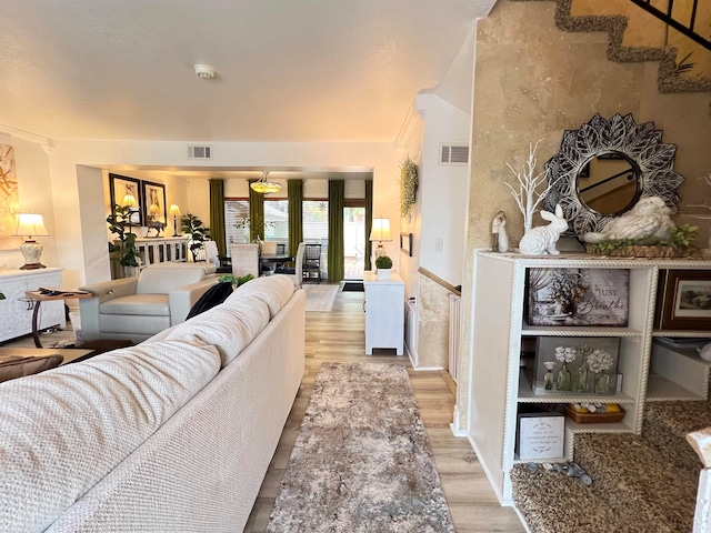 living room with crown molding and light hardwood / wood-style floors