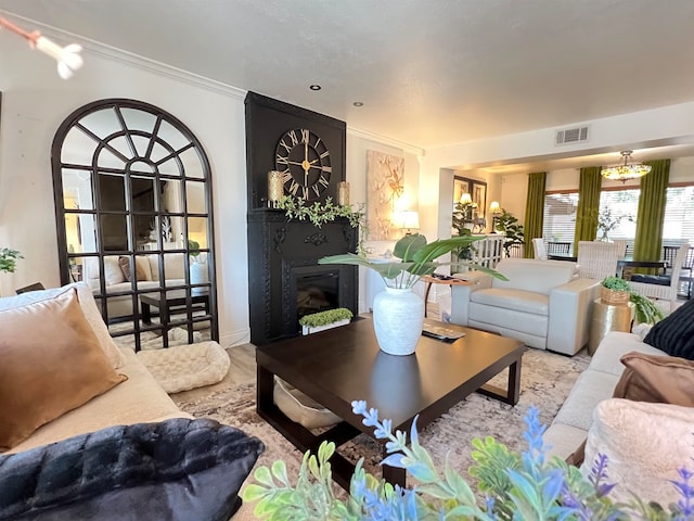 living room featuring crown molding and a large fireplace