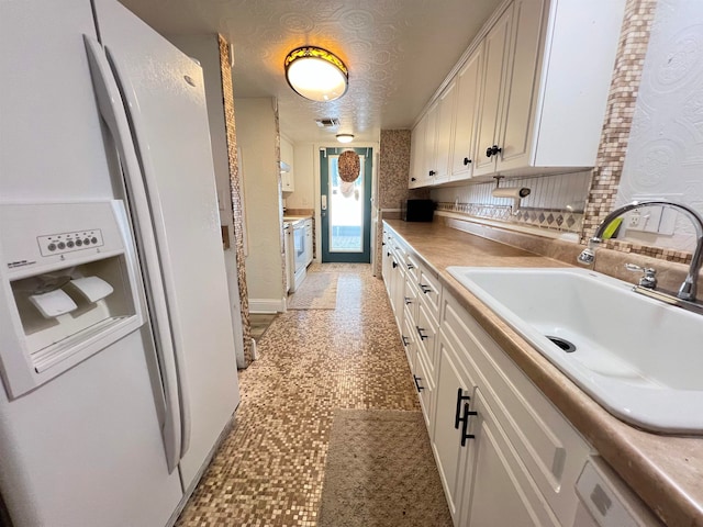 kitchen featuring a textured ceiling, white appliances, sink, and white cabinets