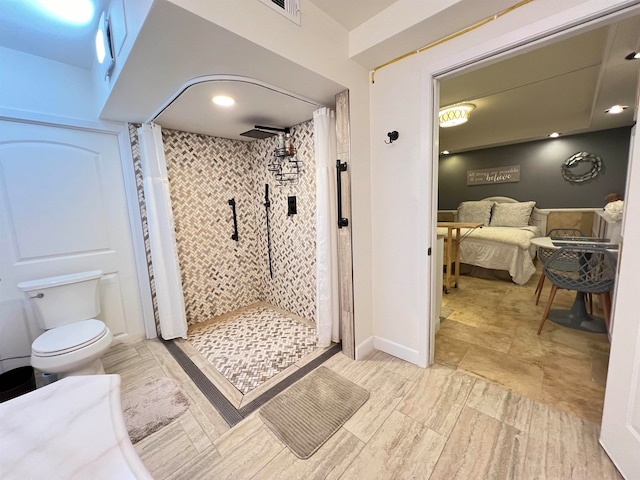 bathroom with a shower with shower curtain and toilet