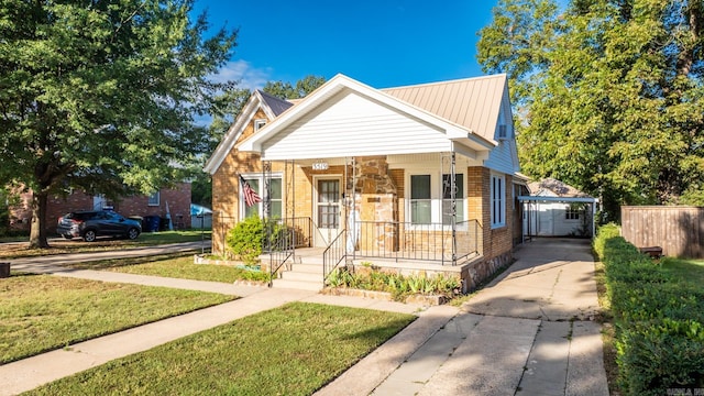 bungalow featuring a front yard, a porch, and a carport