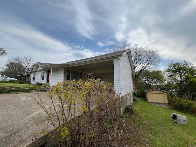 view of side of property featuring an outdoor structure, a garage, and a lawn