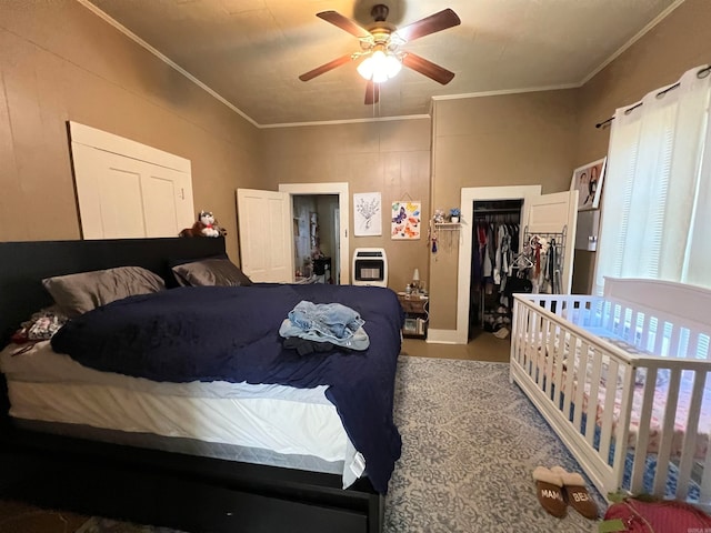 bedroom featuring heating unit, a closet, a walk in closet, crown molding, and ceiling fan