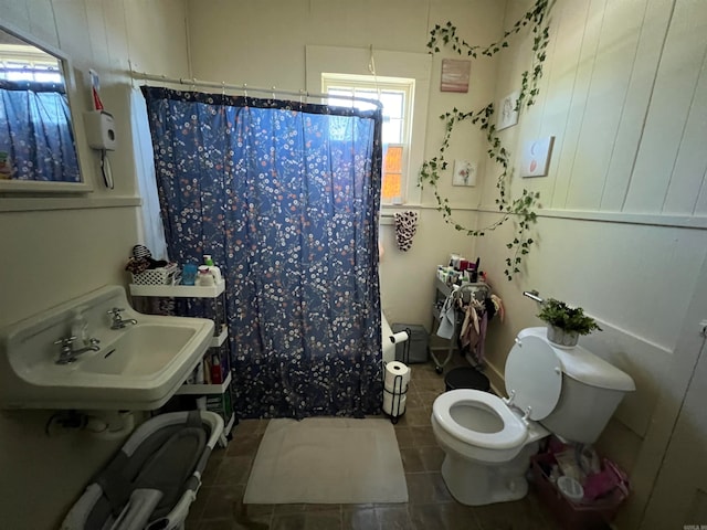 bathroom with walk in shower, sink, toilet, and tile patterned floors