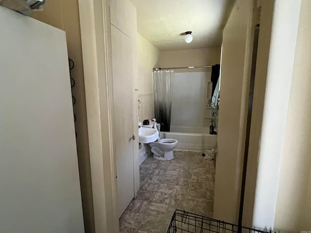 bathroom featuring shower / bath combination with curtain, a bidet, and toilet