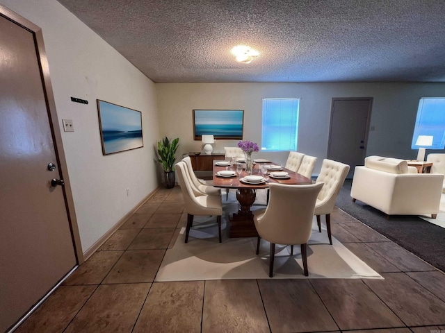 dining area featuring a textured ceiling, tile patterned flooring, and a wealth of natural light