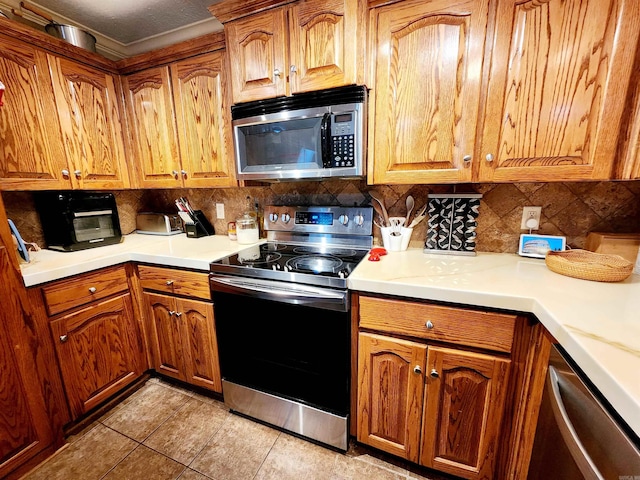 kitchen featuring stainless steel appliances, light tile patterned floors, and tasteful backsplash