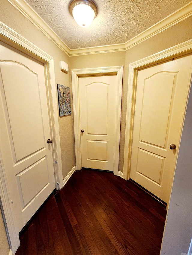 corridor featuring a textured ceiling, ornamental molding, and dark hardwood / wood-style floors