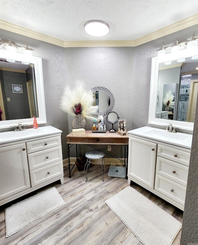 bathroom with vanity, a textured ceiling, crown molding, and hardwood / wood-style floors