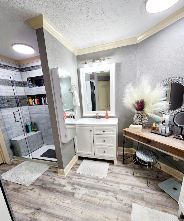 bathroom featuring hardwood / wood-style flooring, a shower with door, vanity, and a textured ceiling