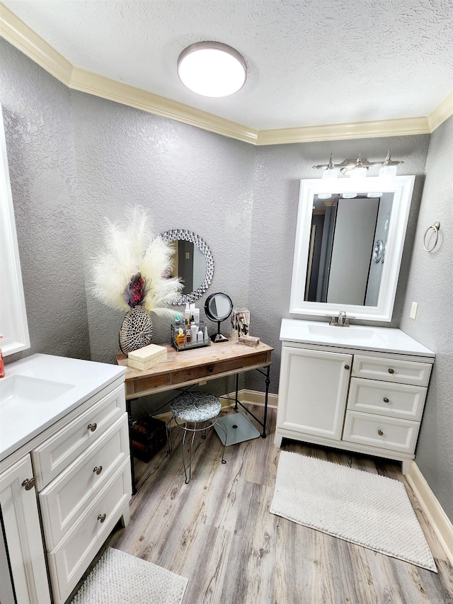 bathroom with vanity, hardwood / wood-style flooring, ornamental molding, and a textured ceiling