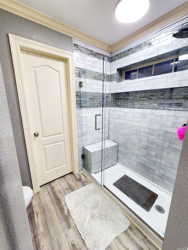 bathroom featuring walk in shower, hardwood / wood-style floors, and toilet