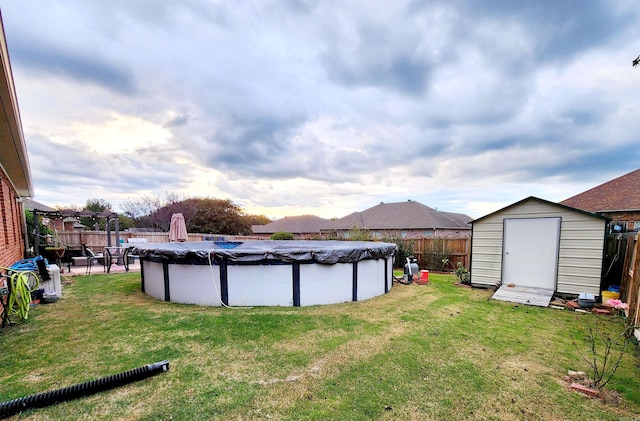 view of yard featuring a covered pool and a storage shed