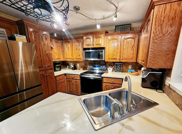 kitchen featuring appliances with stainless steel finishes, decorative backsplash, a textured ceiling, and sink