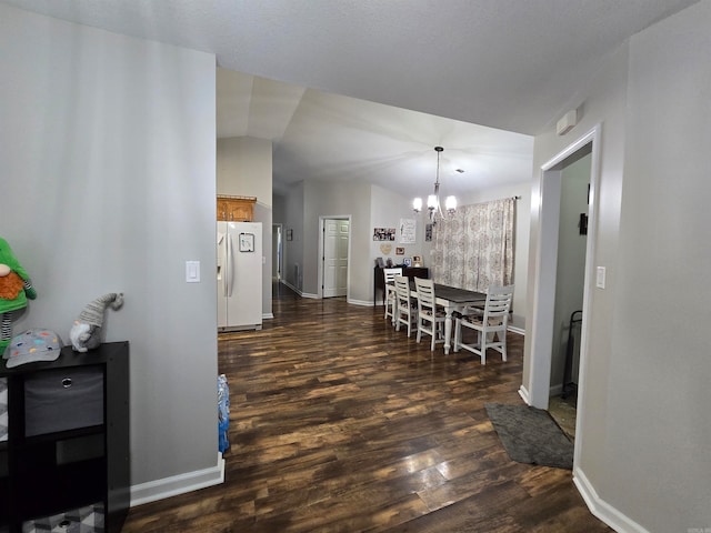 interior space with a notable chandelier, vaulted ceiling, and dark hardwood / wood-style flooring