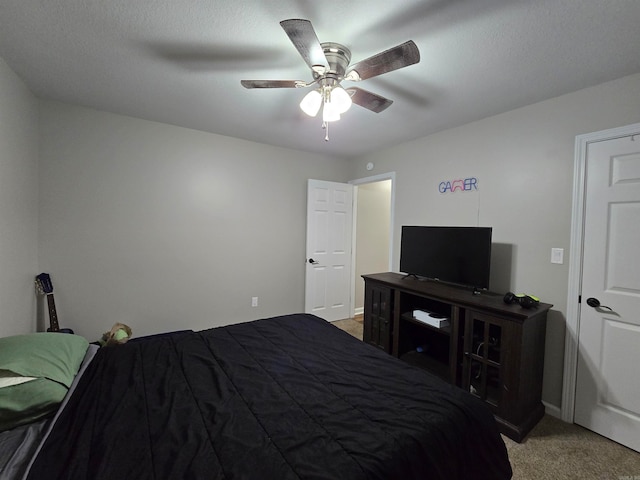 carpeted bedroom featuring a textured ceiling and ceiling fan