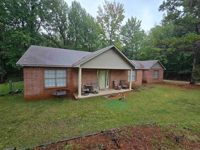 back of property featuring a lawn and a patio area