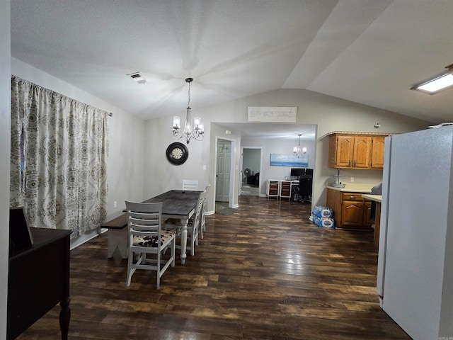 dining room with an inviting chandelier, vaulted ceiling, and dark hardwood / wood-style flooring