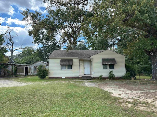 view of front of property featuring a carport and a front yard